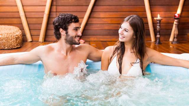 Pareja cenando en un jacuzzi al aire libre durante una escapada romántica de fin de semana