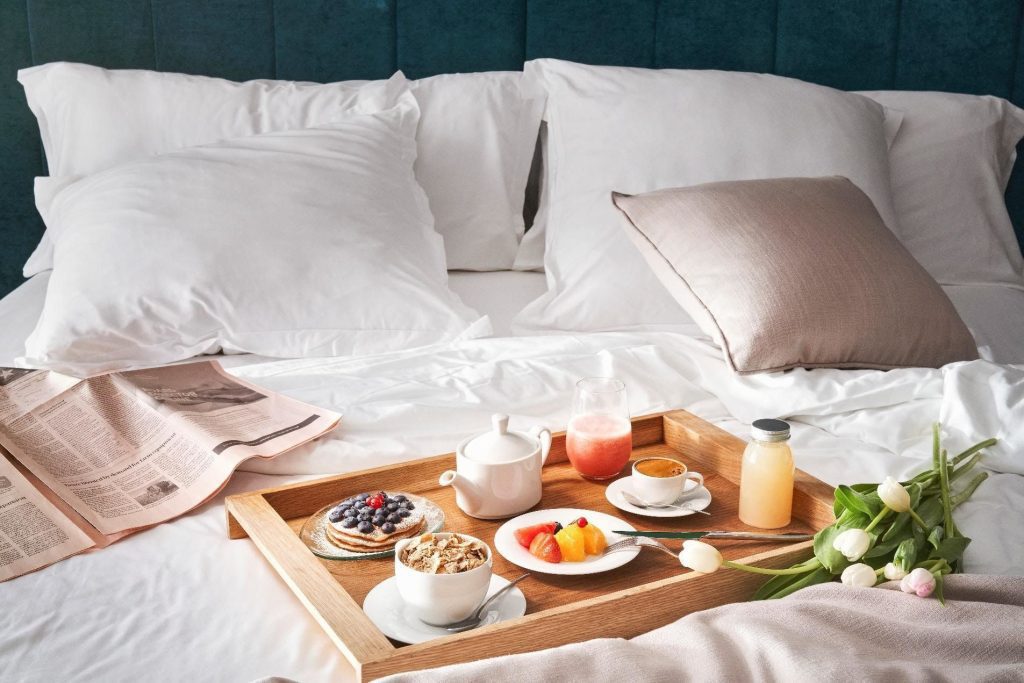 Desayuno en la cama con bandeja de café, frutas y flores, detalle especial disponible en tienda de regalos en Madrid