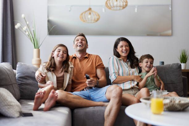 Familia disfrutando de una película juntos en el sofá, momento de ocio y unión familiar en Madrid
