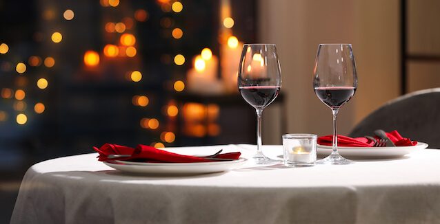 cena romántica con vino y velas en ambiente íntimo