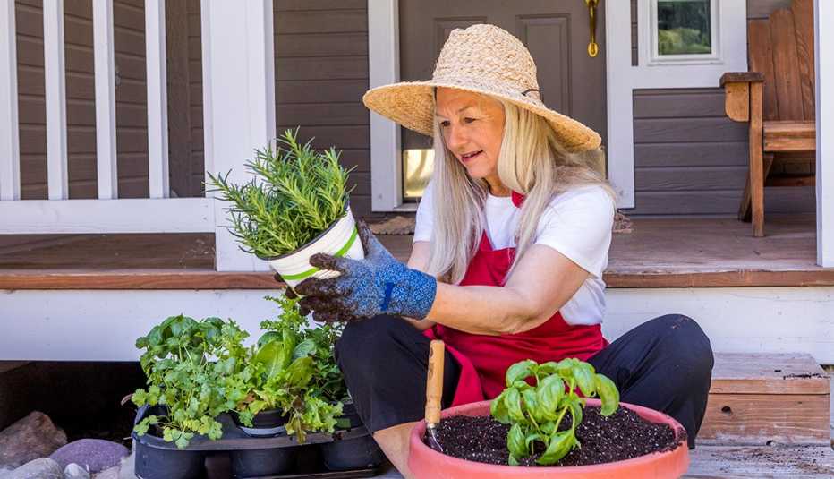Mujer cuidando sus plantas en el jardín con herramientas de jardinería en Madrid