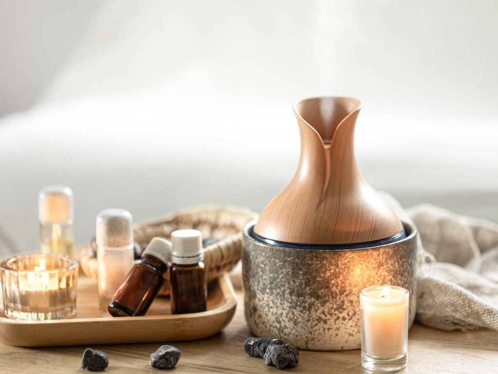 Difusor de aromaterapia con vapor visible y luz LED encendido sobre una mesa