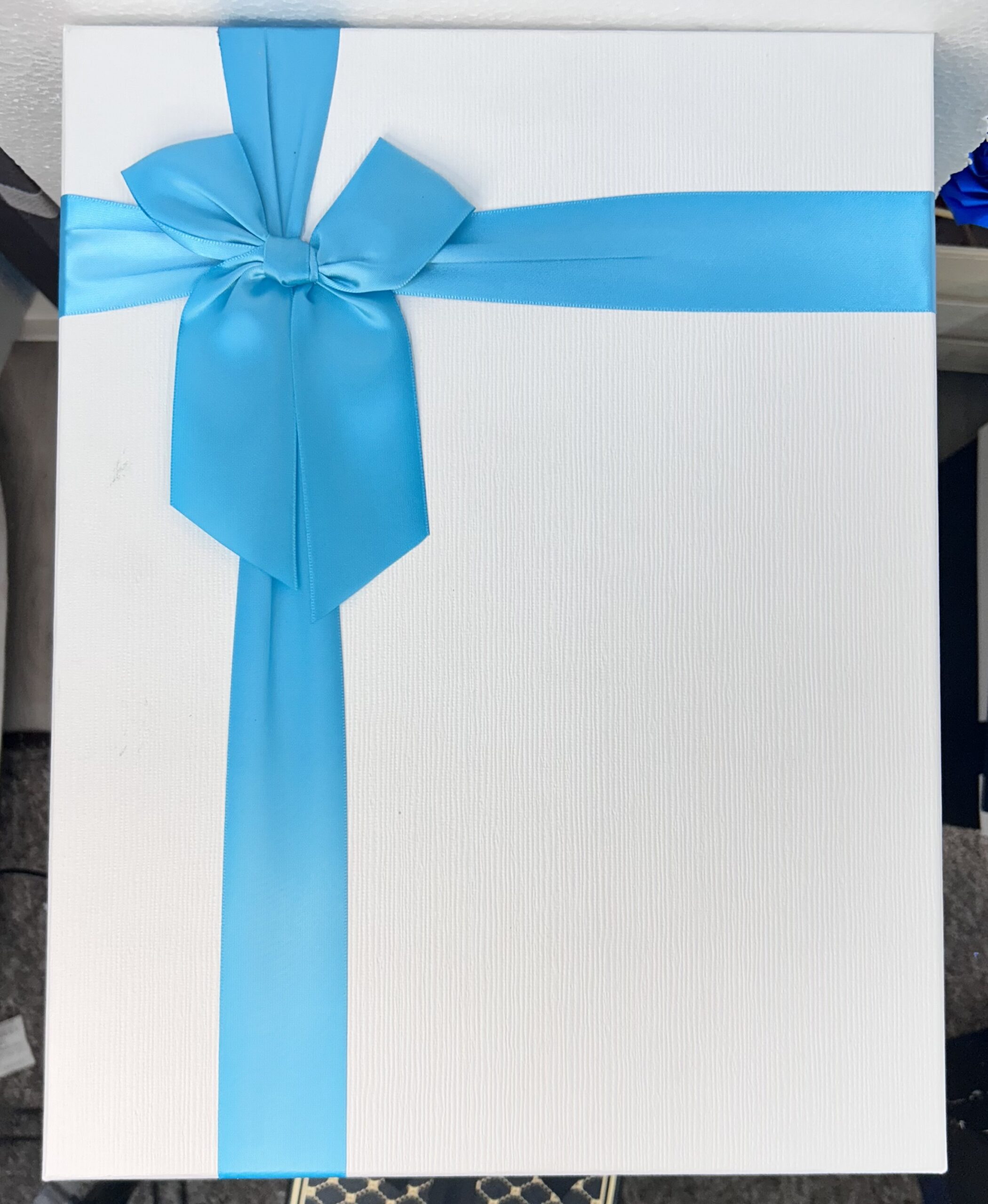 caja de regalo blanca con lazo azul brillante