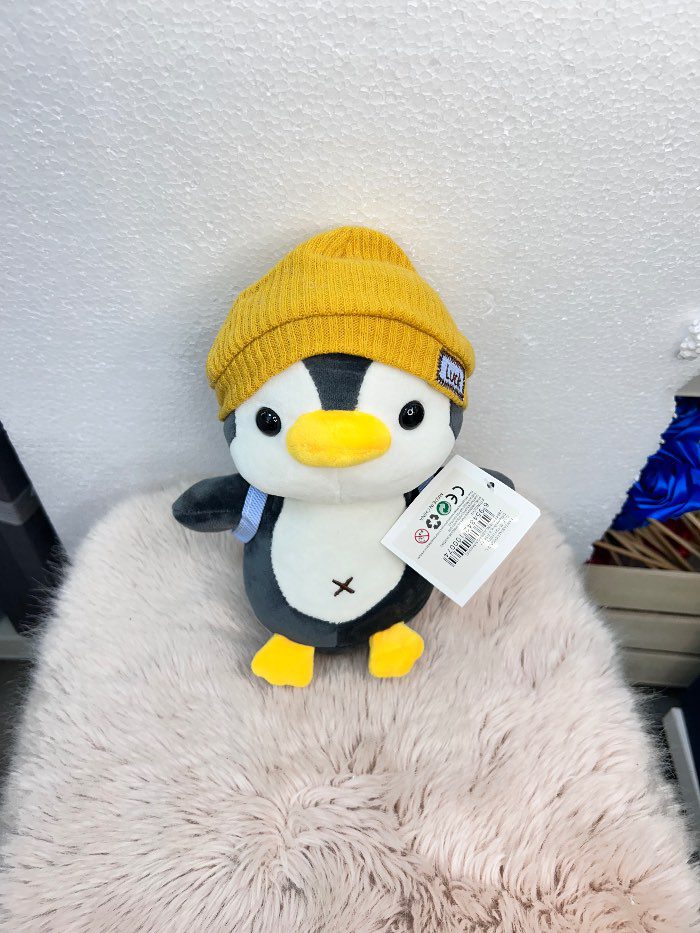 Peluche de pingüino con gorra amarillo