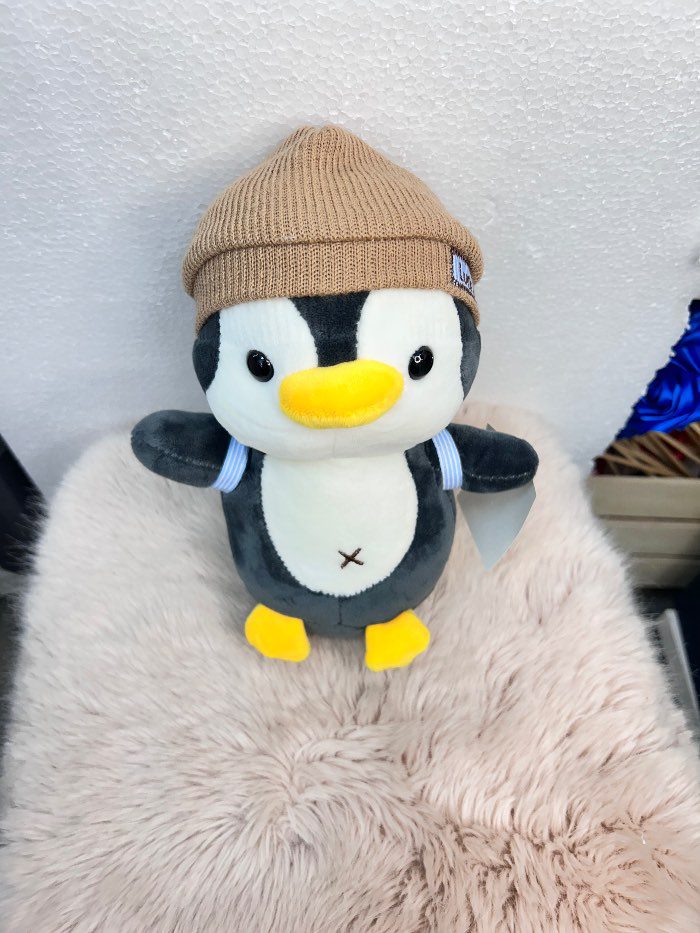 Peluche de pingüino con gorra marron