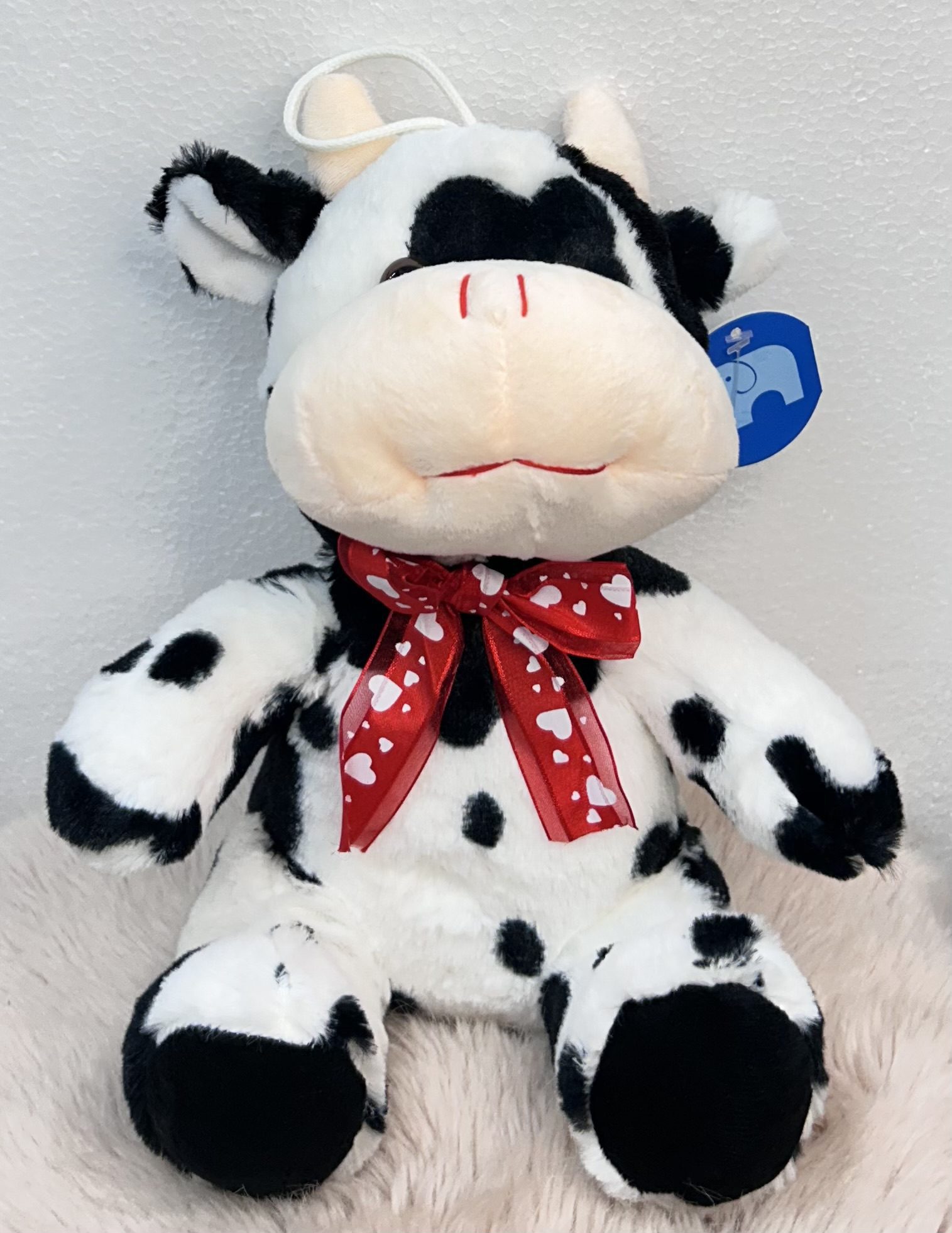 Peluche de vaca con lazo rojo