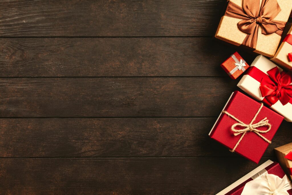 Decorative holiday gift boxes with ribbons on a rustic wooden surface, perfect for seasonal themes.