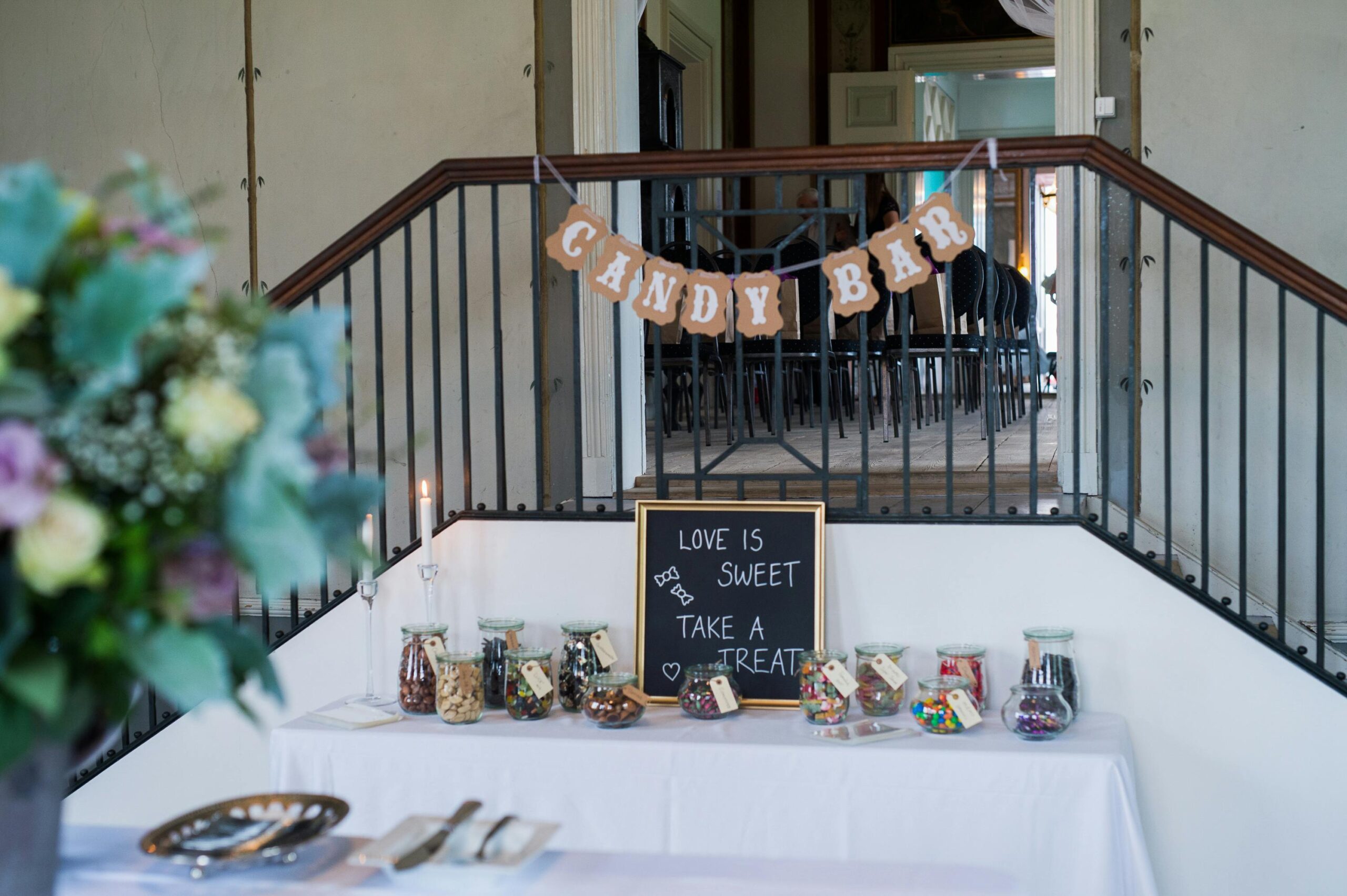 Charming candy bar setup at indoor event with variety of candies in jars and inviting decor.
