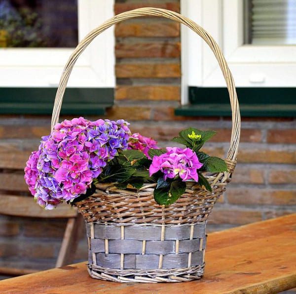 Flores y decoración añadidas a una cesta de regalo
