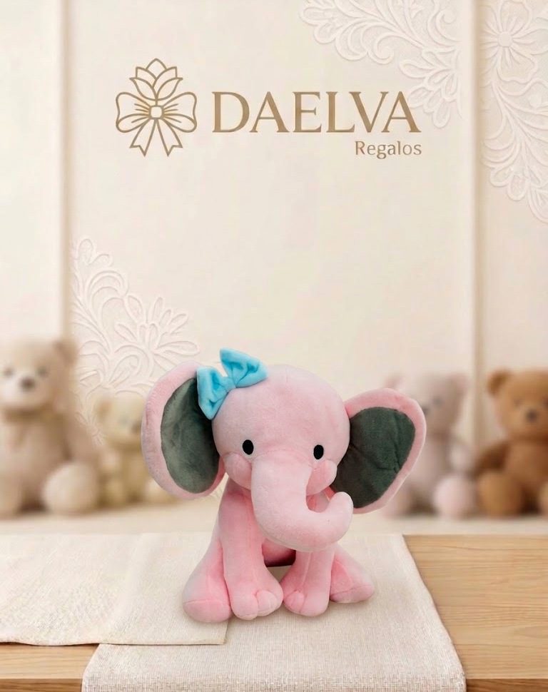 Elefante de peluche rosa sentado con orejas grises, lazo azul y trompa larga