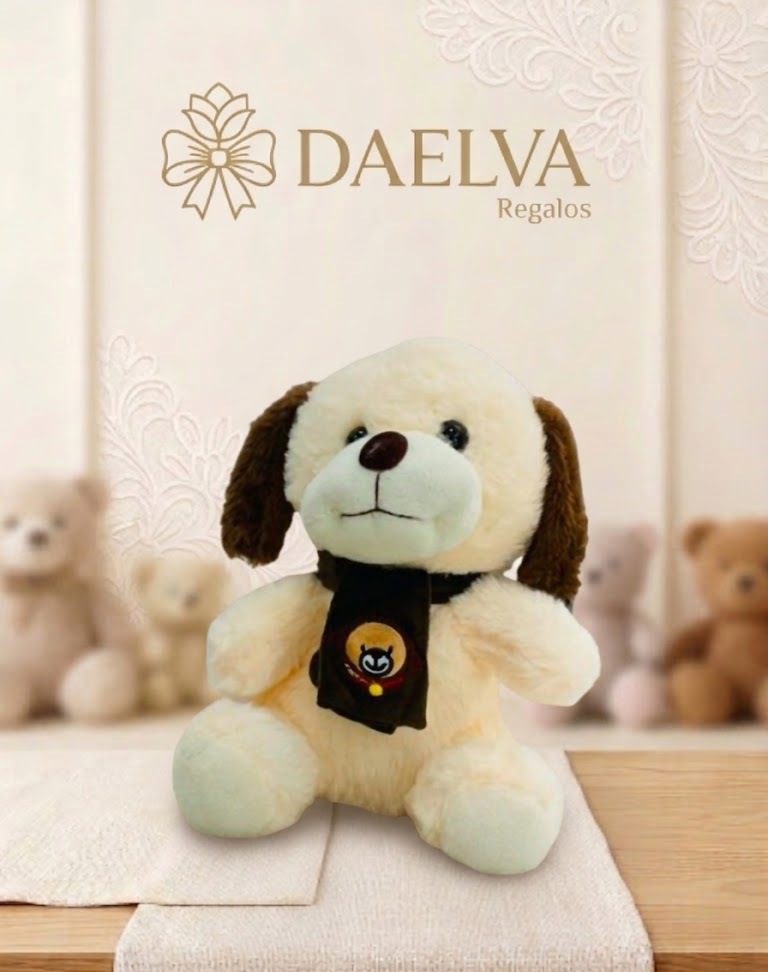 Peluche de perrito crema con bufanda, de pelo suave, orejas marrones y bufanda negra con un dibujo