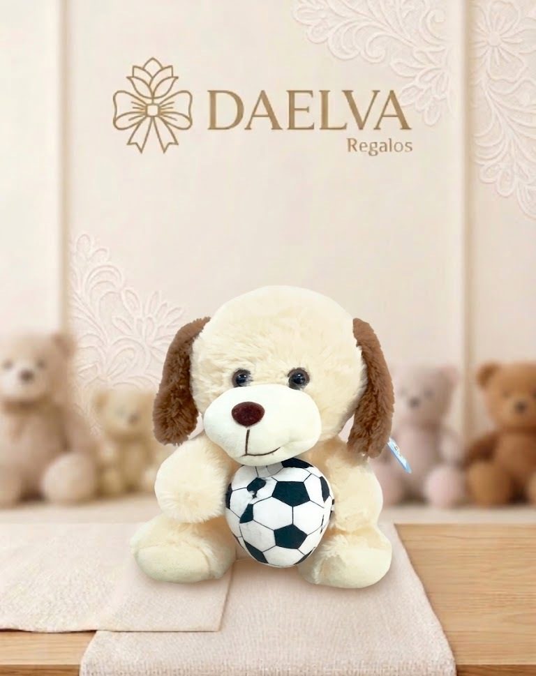 Peluche de perrito con balón de fútbol, de pelo crema y orejas marrones, sentado con un balón entre las patas