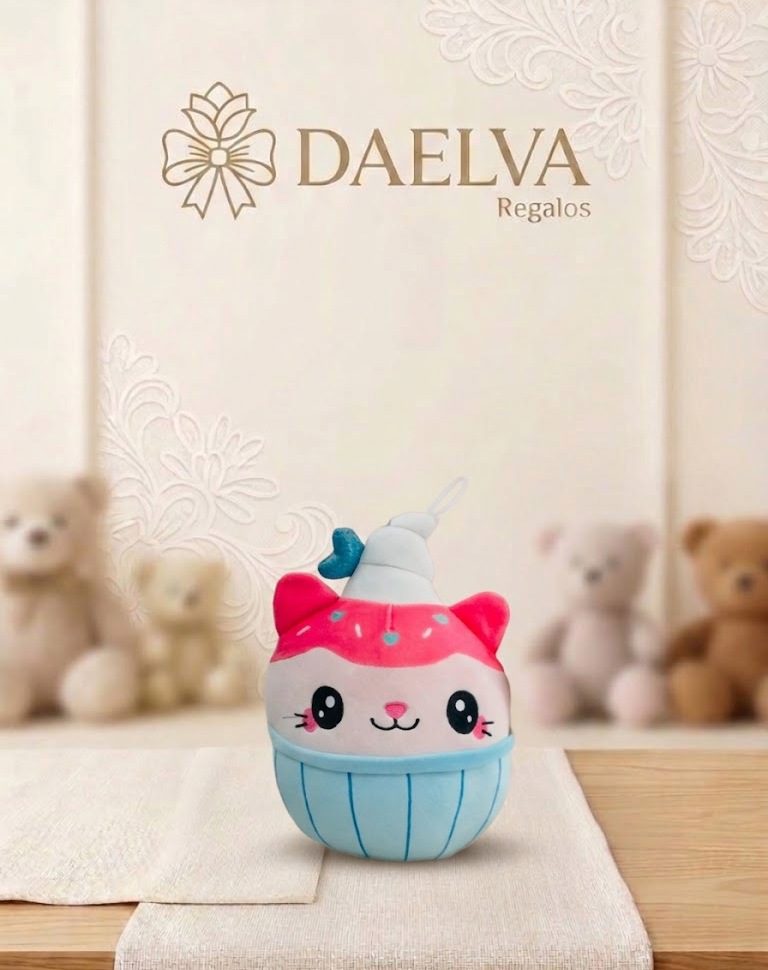 Peluche en forma de cupcake con cara de gato, orejas rosas, glaseado rosa y base azul
