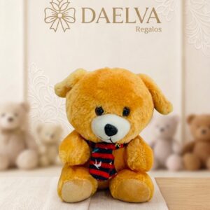 Perrito de peluche amarillo con orejas caídas y bufanda a rayas rojas y negras