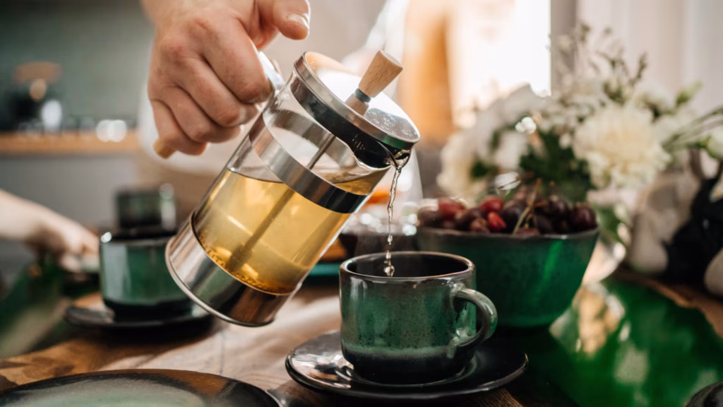 Mano vertiendo una infusión caliente en una taza de cerámica en Madrid