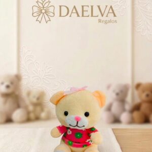 Osito de peluche crema con lazo rosa en la cabeza y camisa rosa con flores verdes